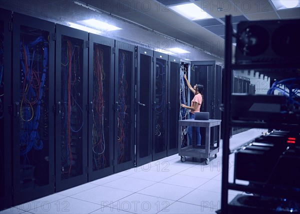 Female technician working in server room