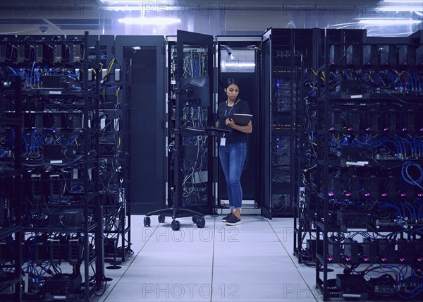 Female technician working in server room