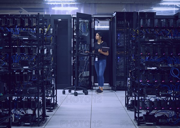 Female technician working in server room