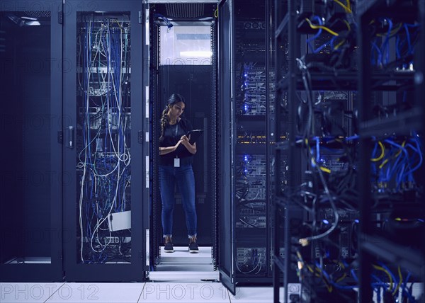 Female technician working in server room