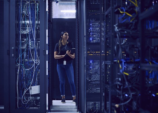 Female technician working in server room