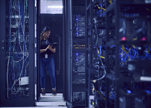 Female technician working in server room