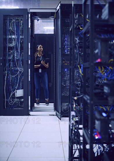 Female technician working in server room