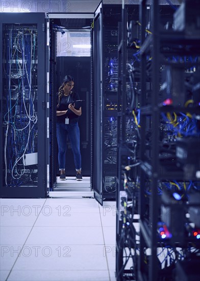 Female technician working in server room