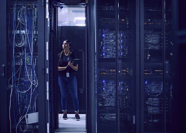 Female technician working in server room