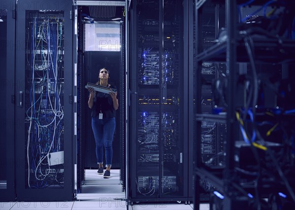 Female technician carrying hard drive in server room