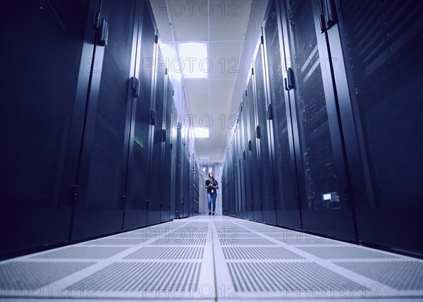 Female technician working in server room