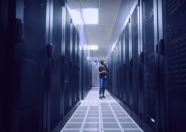 Female technician working in server room