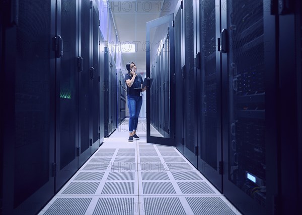 Female technician working in server room