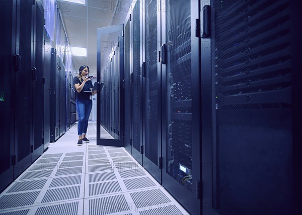 Female technician working in server room