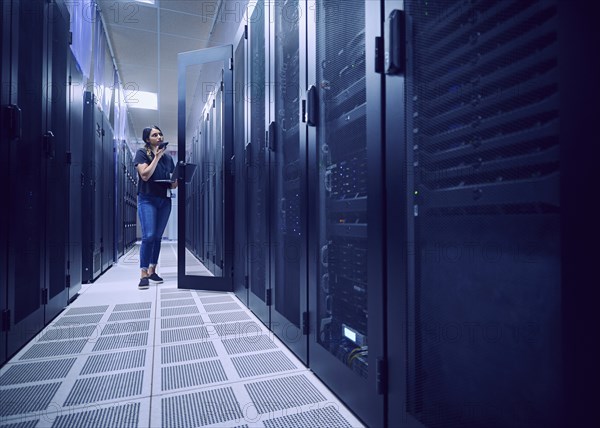 Female technician working in server room