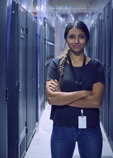 Portrait of smiling female technician standing in server room