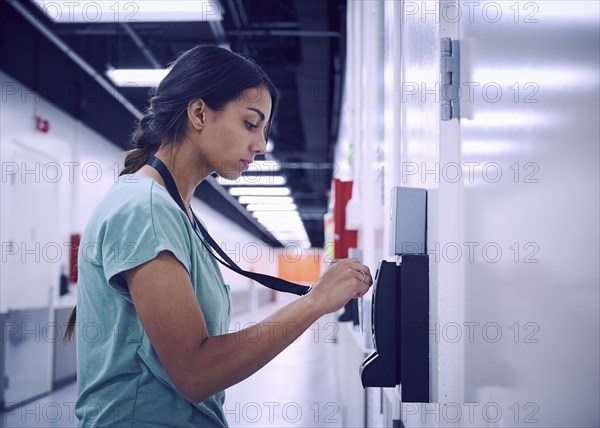 Woman using keycard and digital door lock in office