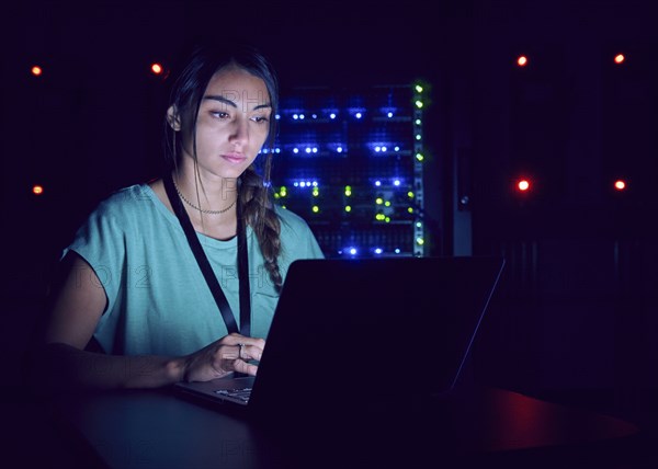 Technician using laptop in server room