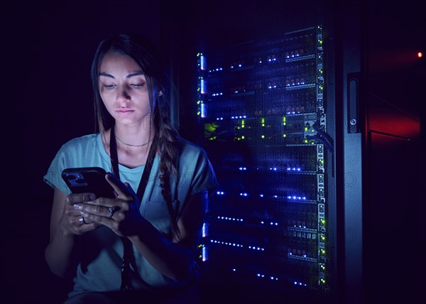 Technician using smart phone in server room