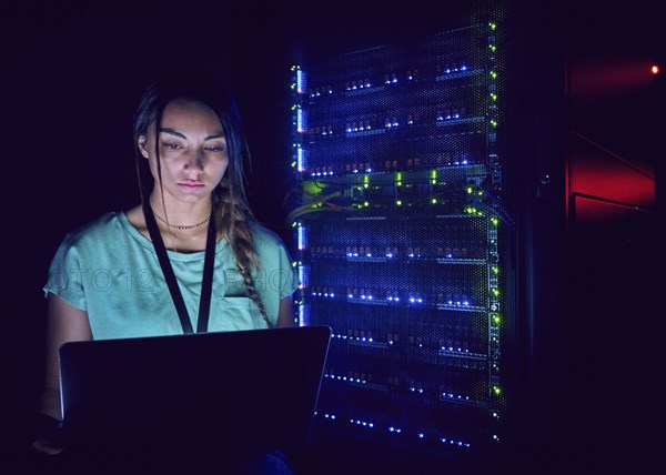 Technician using laptop in server room