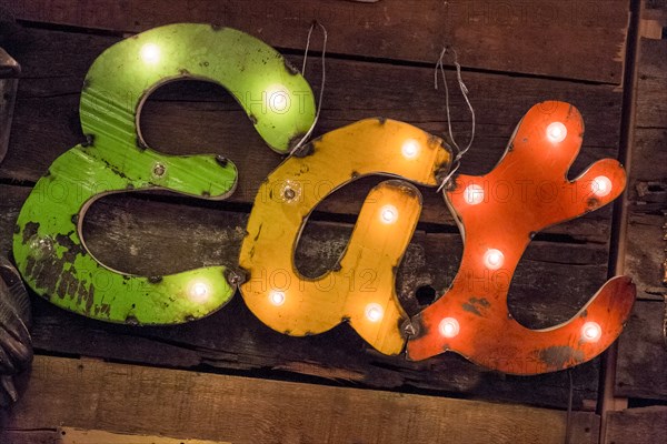 Old illuminated restaurant sign on wooden surface