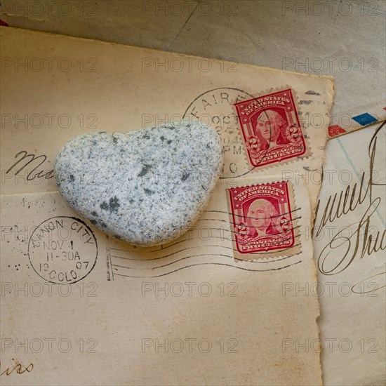 Old envelopes with stamps and heart shaped stone