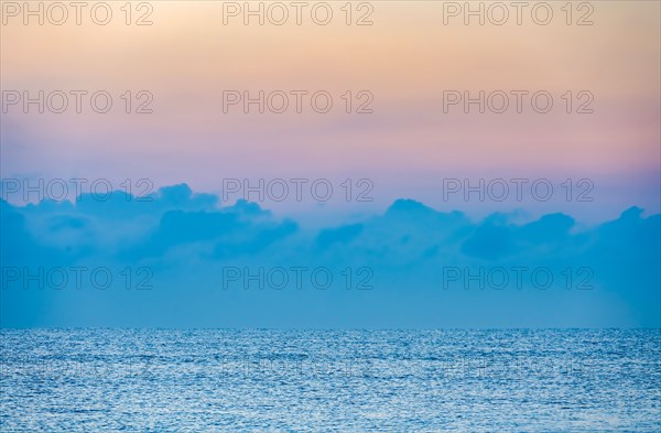 Clouds above calm ocean at sunrise