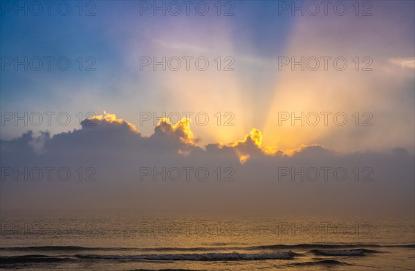 Sun rising above calm ocean