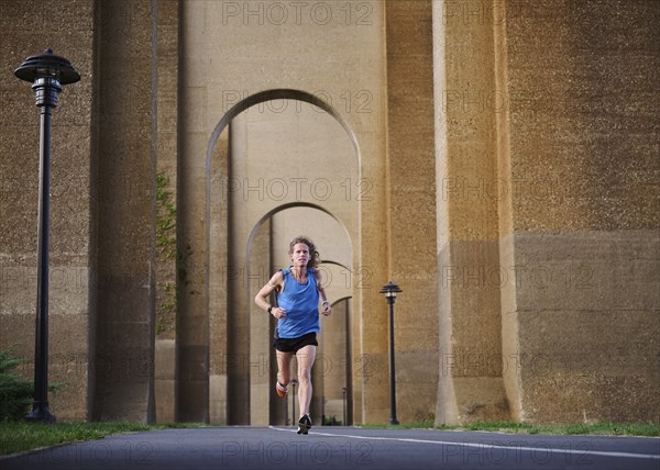 Man jogging under bridge