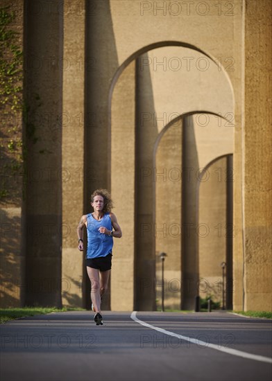 Man jogging under bridge