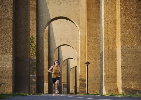 Man jogging under bridge