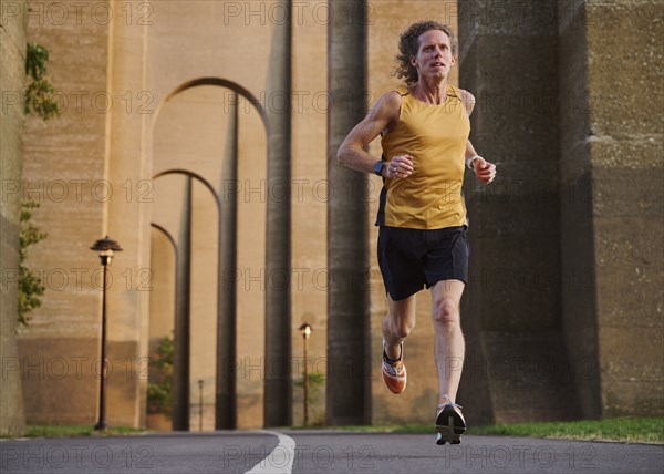 Man jogging under bridge