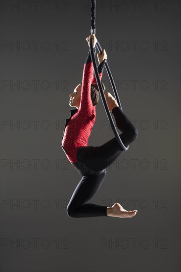 Young acrobat performing on aerial hoop