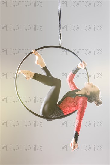 Young acrobat performing on aerial hoop