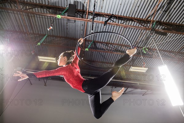 Young acrobat performing on aerial hoop