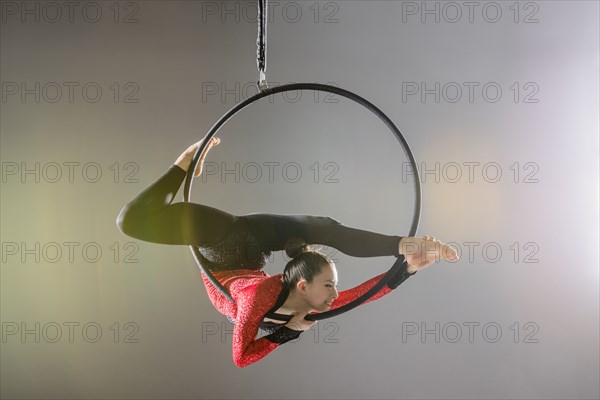 Young acrobat performing on aerial hoop