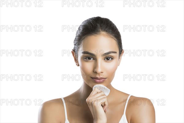 Portrait of young woman holding cotton pad