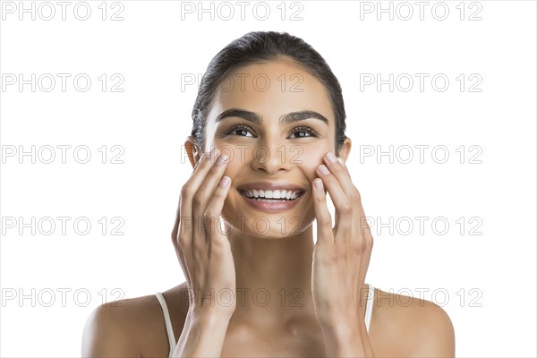 Portrait of young woman doing face massage