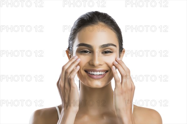 Portrait of young woman doing face massage