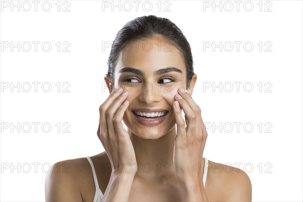 Portrait of young woman doing face massage