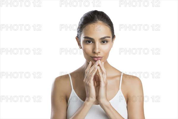 Portrait of serious young woman with hands clasped