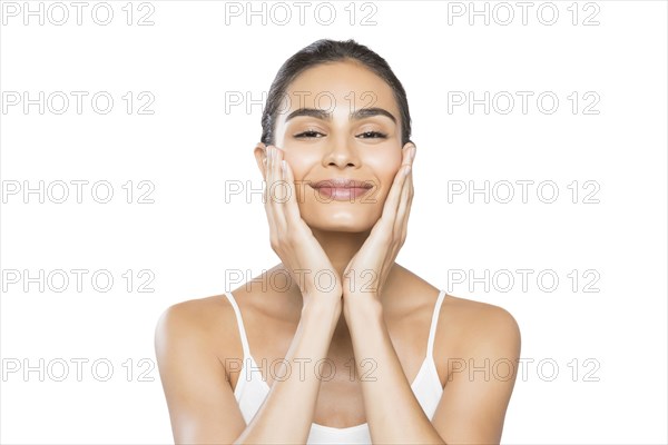 Portrait of smiling young woman doing facial massage