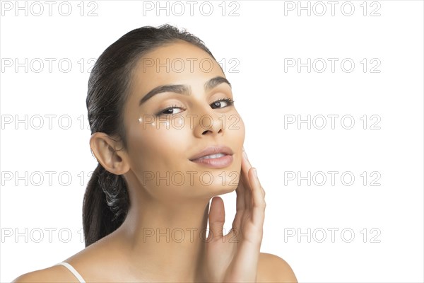 Portrait of smiling young woman applying face cream