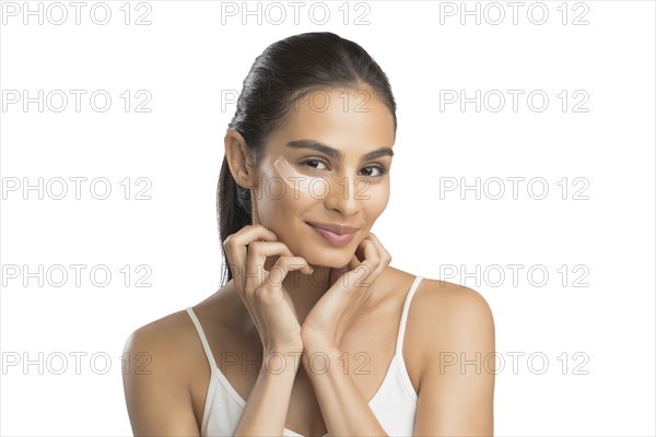 Portrait of young woman with face cream