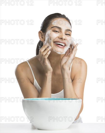 Portrait of young woman enjoying washing face