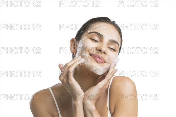 Portrait of young woman enjoying washing face