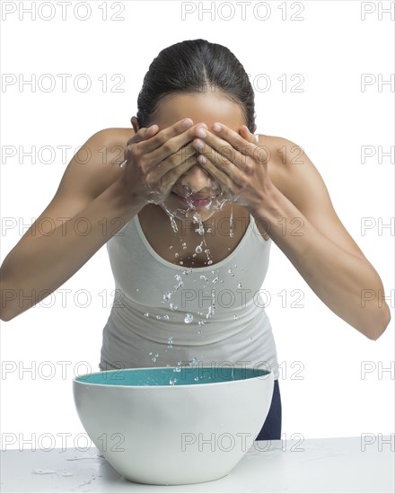 Portrait of young woman washing face