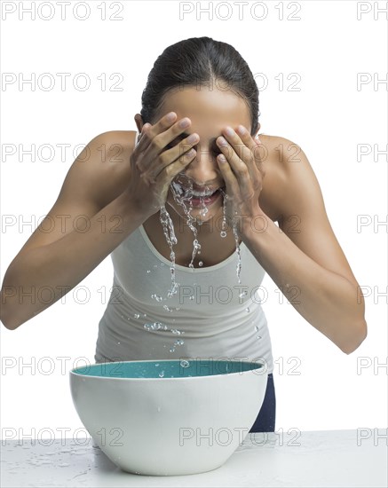 Portrait of young woman washing face