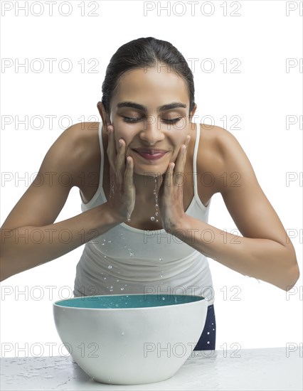 Portrait of young woman washing face