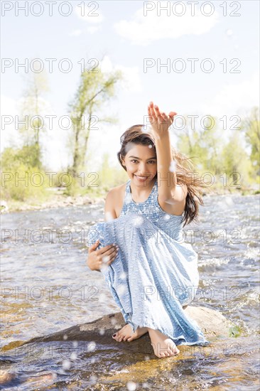 Portrait of beautiful woman in long dress by river