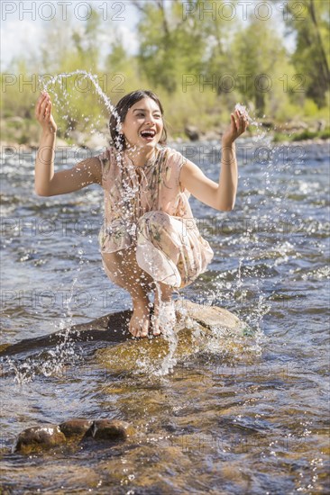 Portrait of beautiful woman in long dress by river