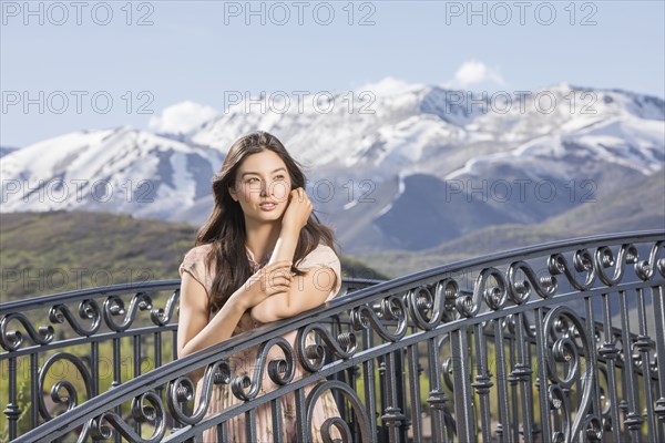 Portrait of beautiful woman on footbridge in mountain scenery