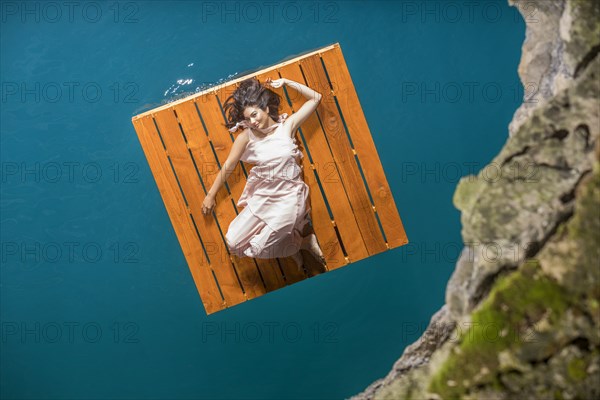 Aerial view of woman lying on wooden raft