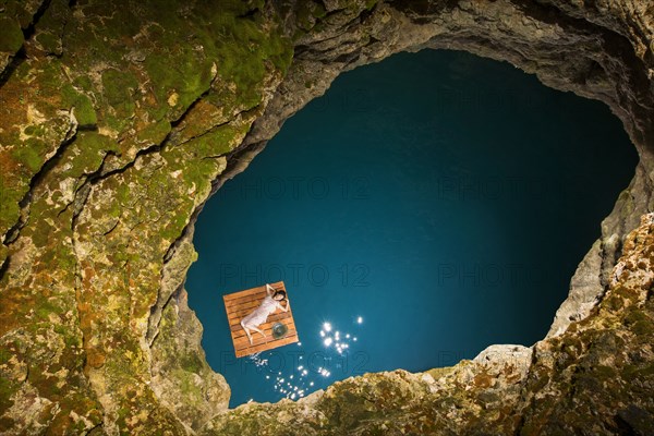 Aerial view of woman lying on wooden raft